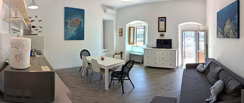 La stanza grande: cucina, tavolo e divano letto